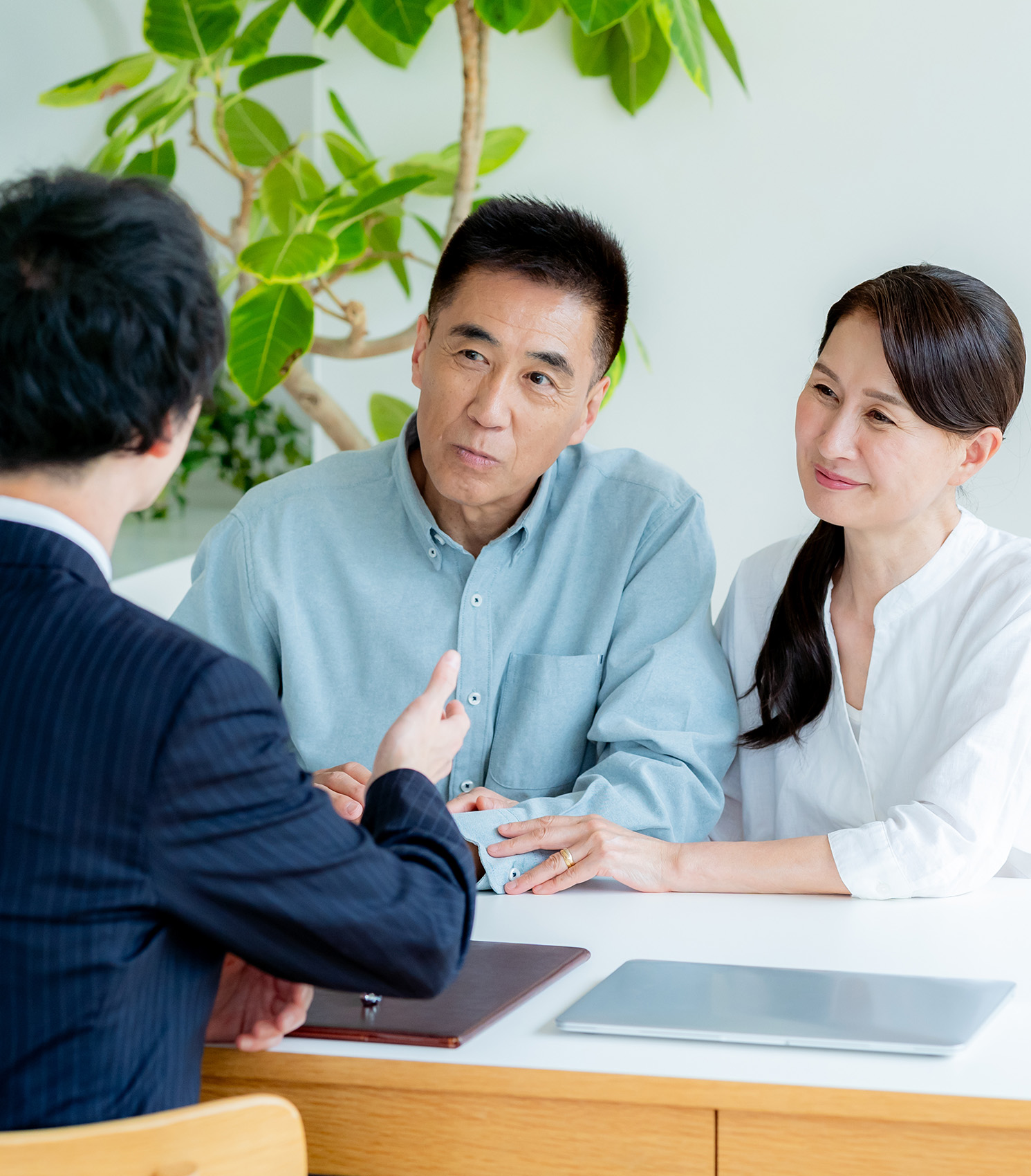 専門スタッフに賃貸中マンションの売却を相談するオーナー夫妻