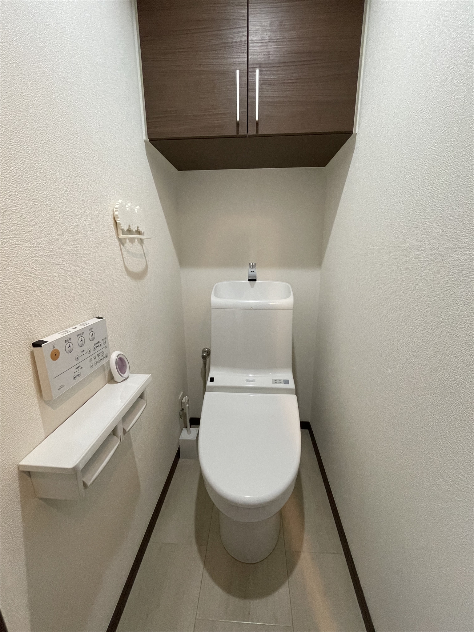 清潔感のあるトイレ。ストック用品や清掃用品も収納できる戸棚付き。(2022年5月)