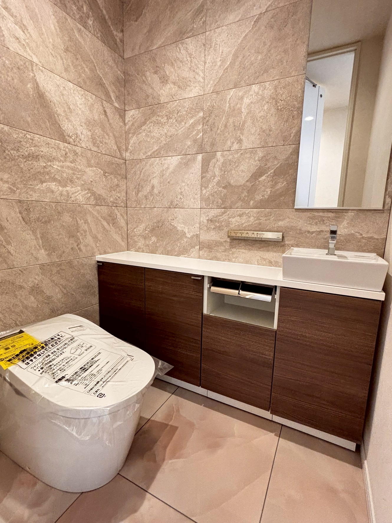 【トイレ】石目調の壁面が上質感を演出するトイレ空間。手洗いカウンター付きで、使い勝手にも配慮されています。(2026年5月)