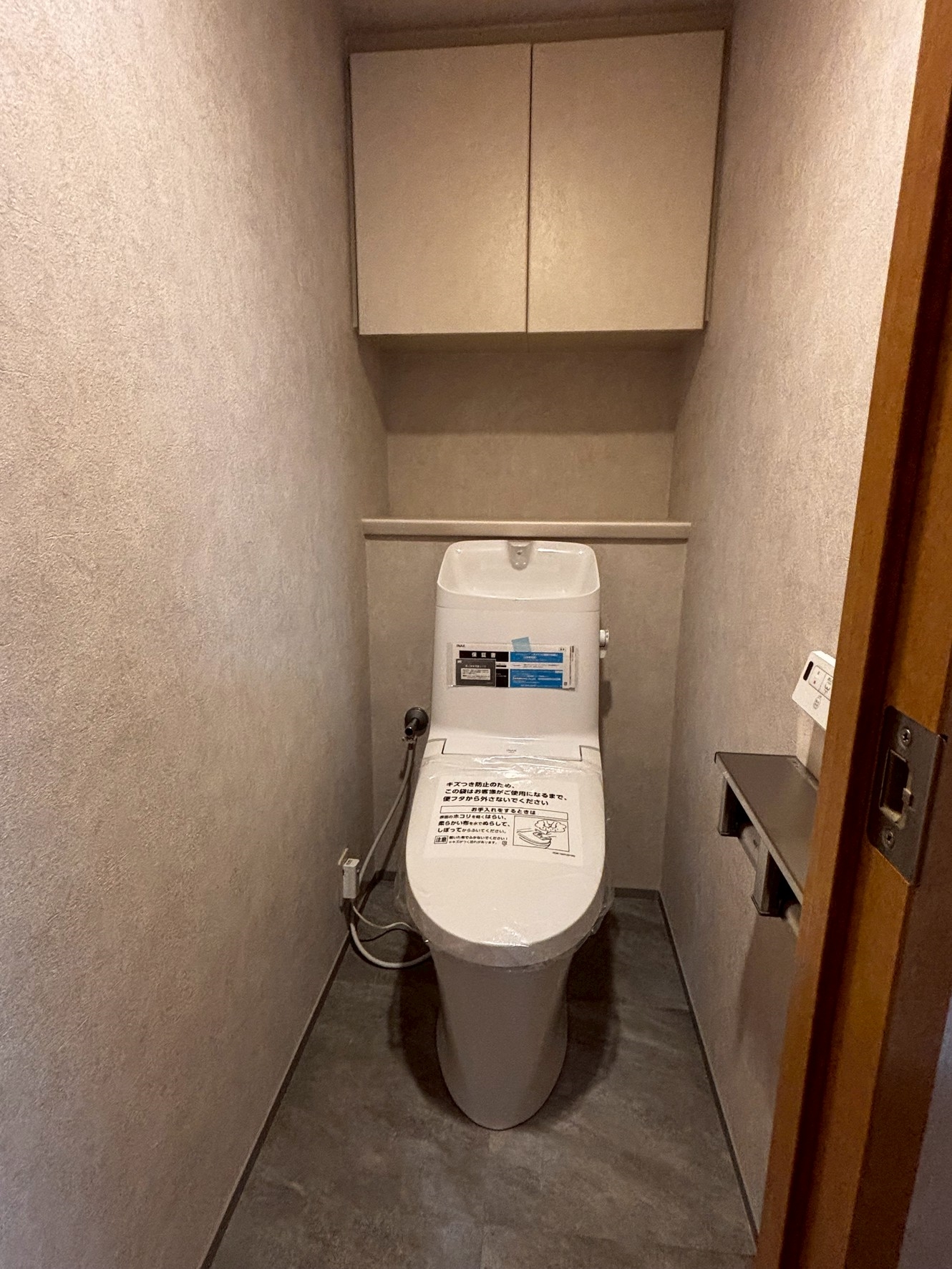 【トイレ】吊戸棚付きで空間を有効活用した、清潔感のあるトイレ空間。(2026年5月)
