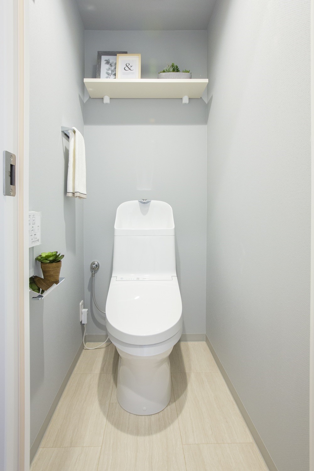 温水洗浄便座付トイレ。上部には収納スペースを設置しており、トイレットペーパーや掃除用品をしまえます。(2021年10月)