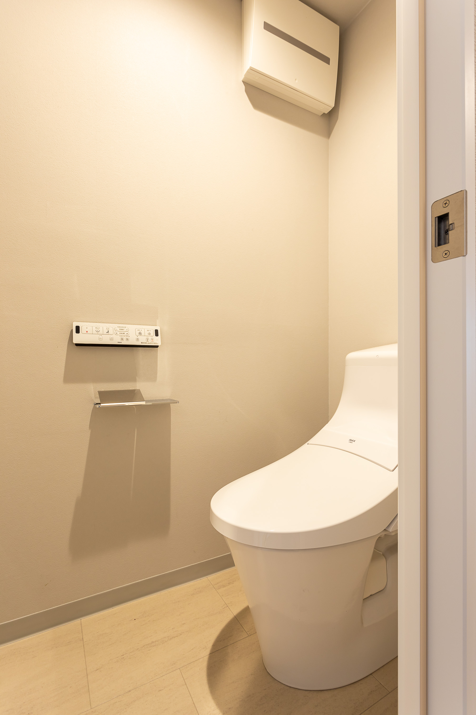 温水洗浄便座付トイレ。上部には収納スペースを設置しており、トイレットペーパーや掃除用品をしまえます。(2022年2月)