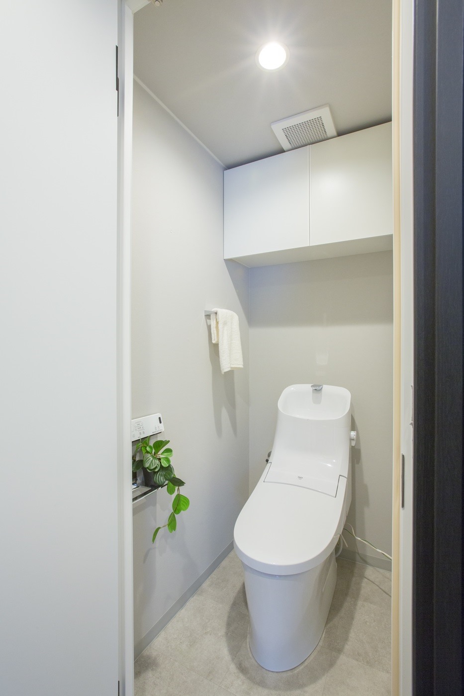 温水洗浄便座付トイレ。上部には収納スペースを設置しており、トイレットペーパーや掃除用品が収納可能。(2022年1月)