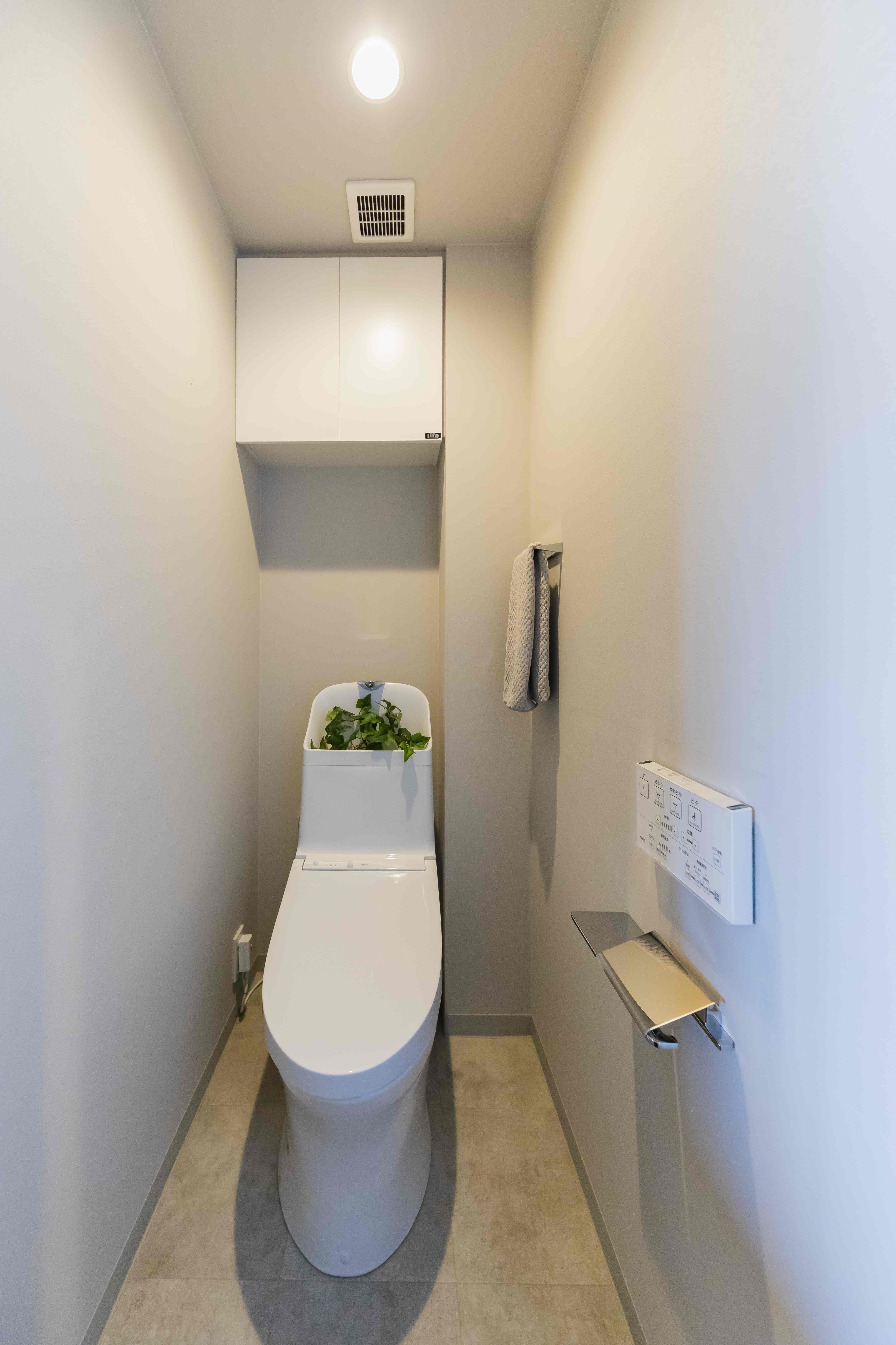 温水洗浄便座付トイレ。収納スペースを設置しており、トイレットペーパーや掃除用品をしまって頂けます。(2022年5月)