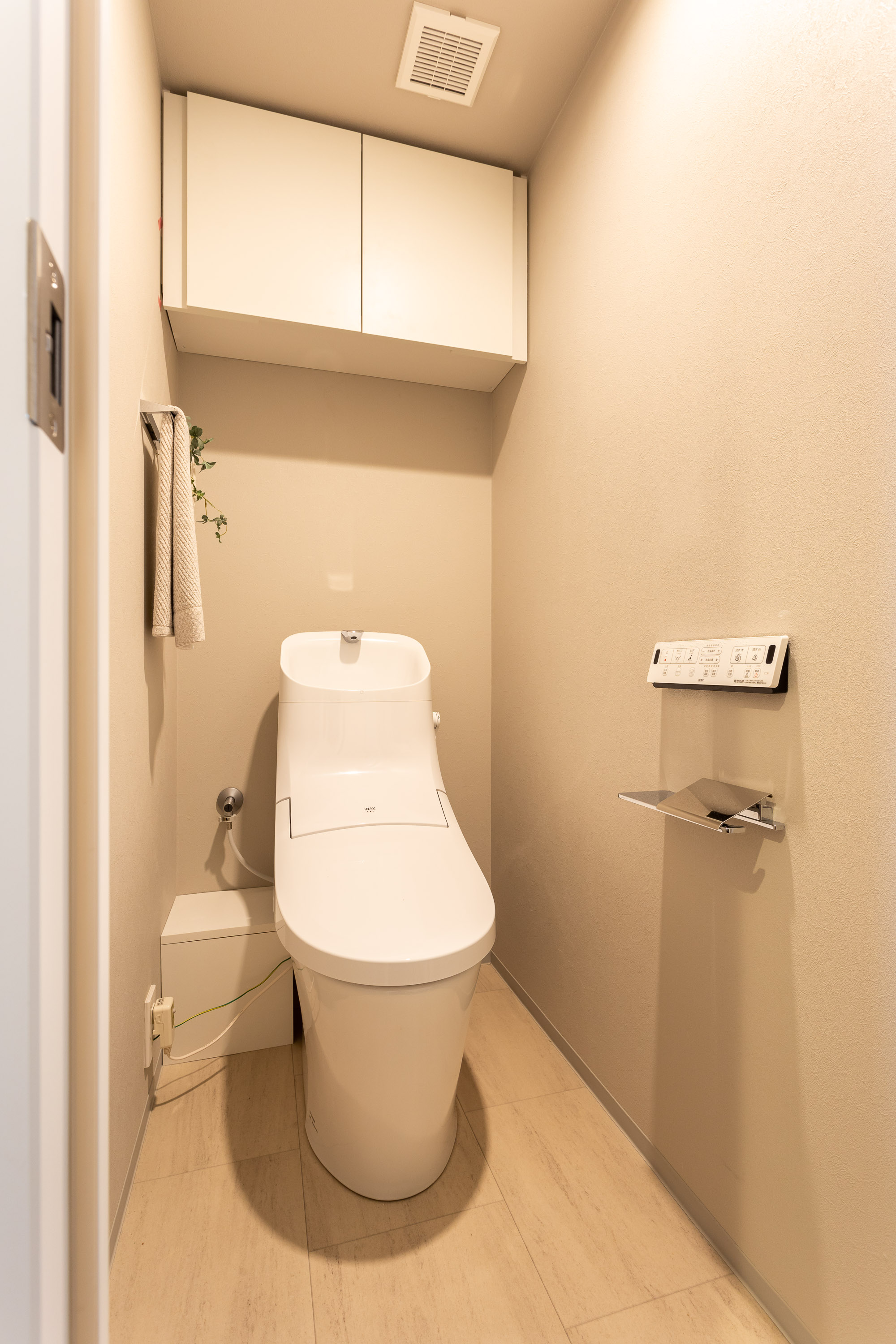温水洗浄便座付トイレ。上部には収納スペースを設置しており、トイレットペーパーや掃除用品をしまえます。