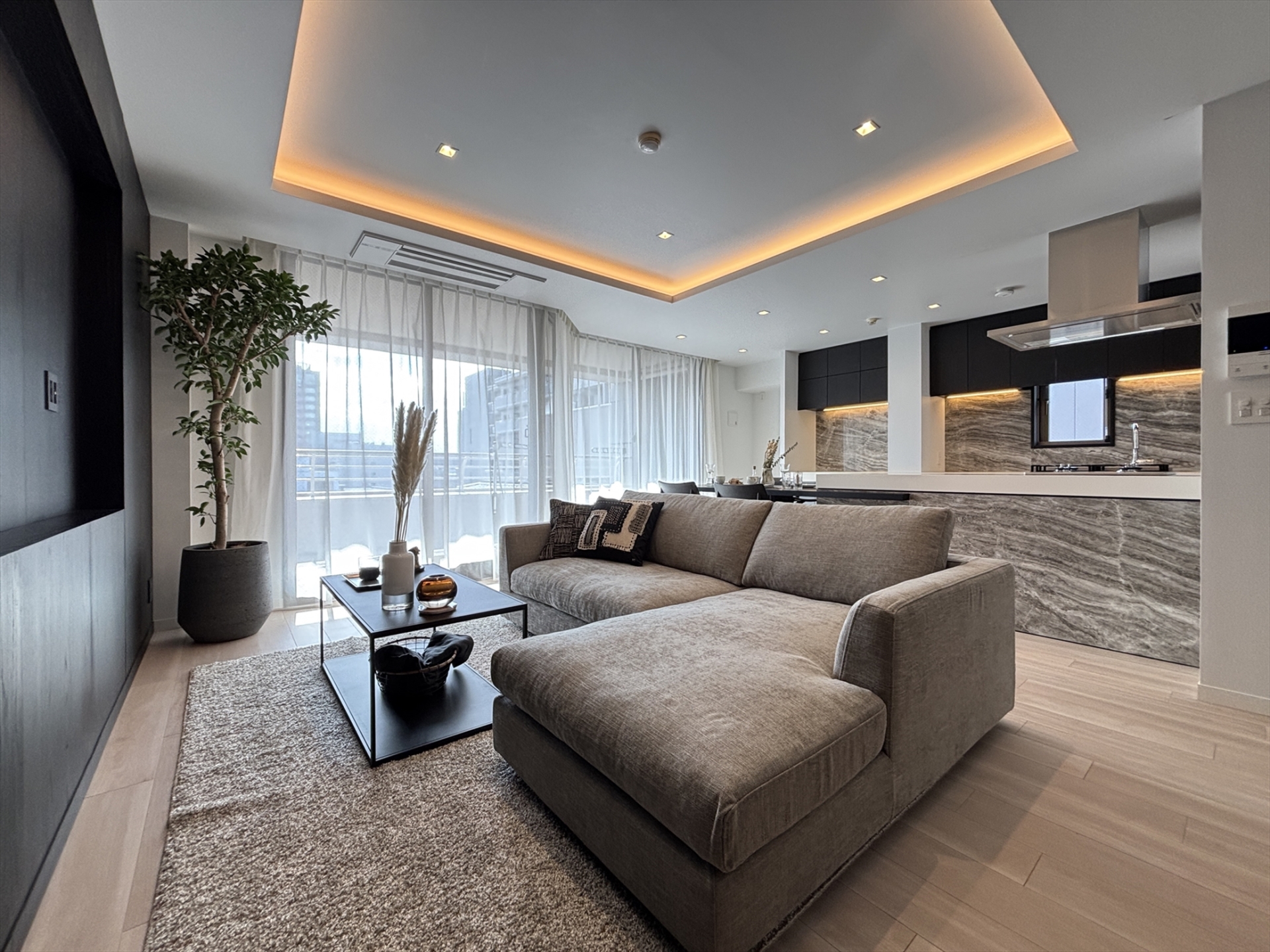 【リビング】LDK約19.2帖。リビングの壁一面には黒浮造りの突板を採用し、上質な素材感が際立つ空間に。(2026年1月)