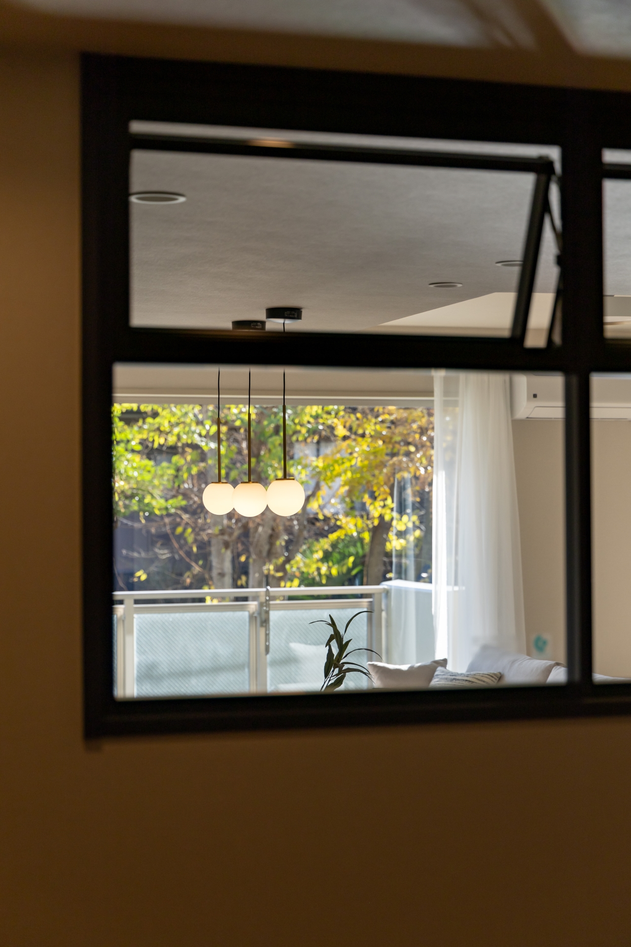 【その他内観】室内窓。廊下から南側の日差しとグリーンが目に飛び込みます。夜は帰宅時に灯りが見えてほっとする空間に。(2025年12月)