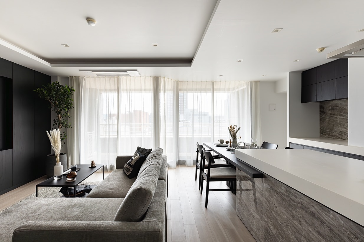 【リビング】ベージュトーンに重厚感ある黒を差し色とし、大理石や木、ガラスなど上質な素材を組み合わせた空間に。(2026年4月)