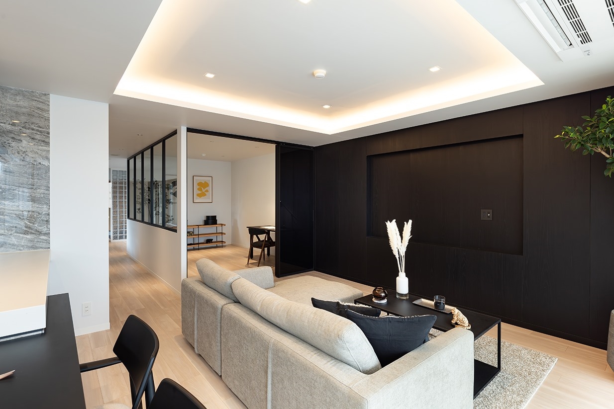 【リビング】LDK約19.2帖。リビングの壁一面には黒浮造りの突板を採用し、上質な素材感が際立つ空間に。(2026年4月)