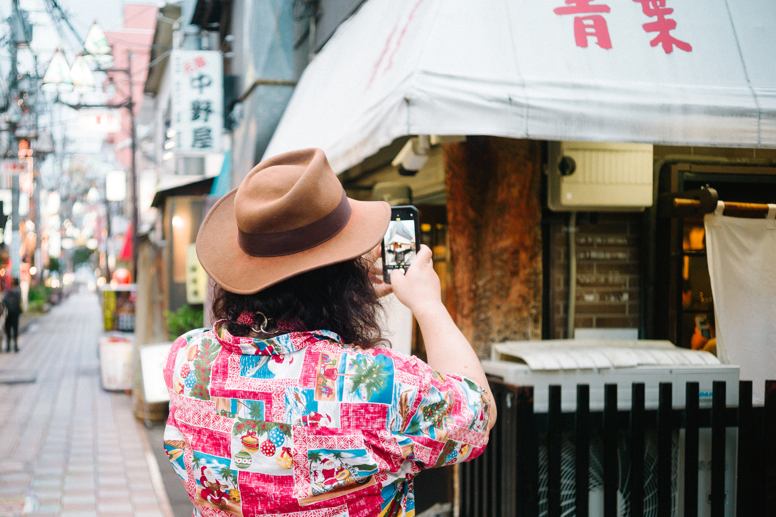 中野の商店街で写真を撮る高山 洋平さん